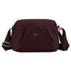 Bordeauxrote, handliche Damen-Umhängetasche aus Polyester, aufgehängt an einem breiten Gürtel - Peterson